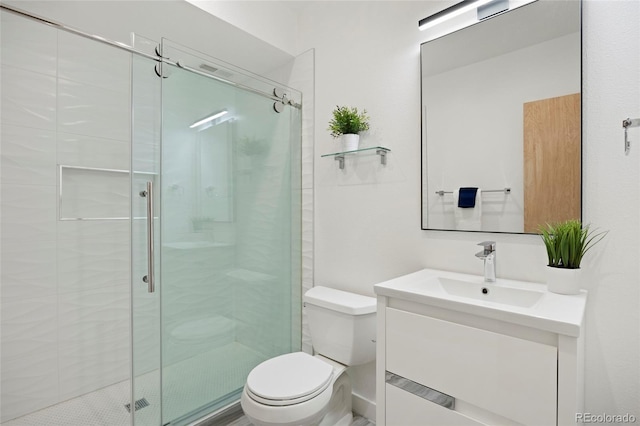 bathroom featuring a shower with door, vanity, and toilet