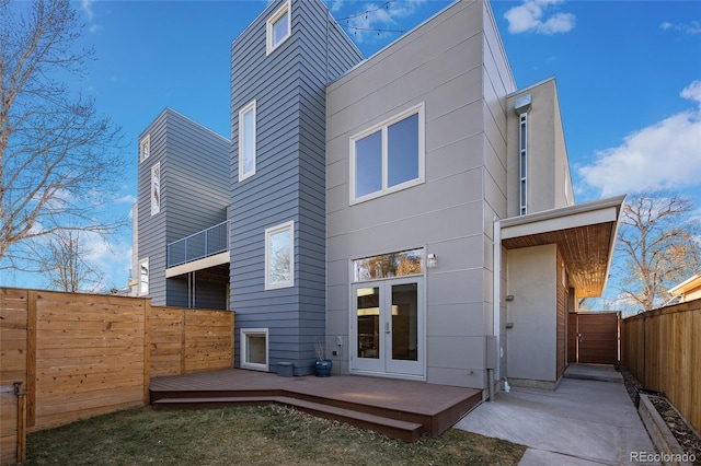 back of house featuring a fenced backyard, a wooden deck, and french doors