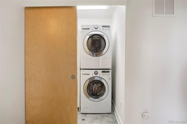 laundry room featuring laundry area, stacked washer and clothes dryer, and visible vents