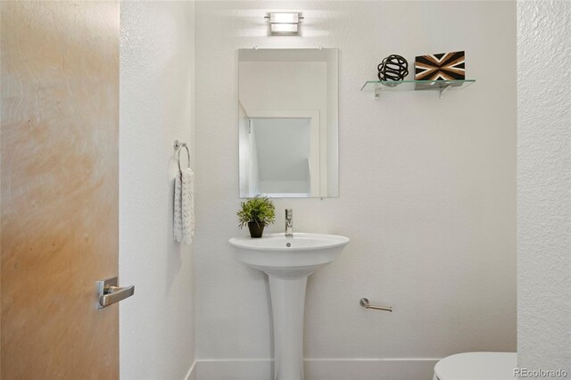 bathroom featuring toilet and baseboards