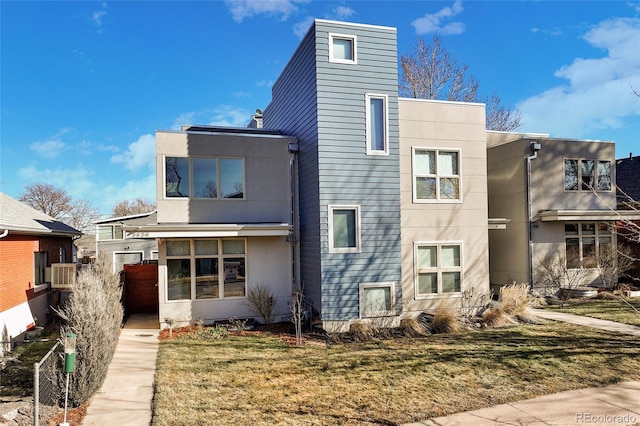 view of front of house with a front yard and stucco siding