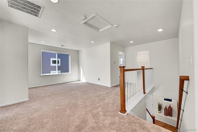 empty room featuring carpet floors, recessed lighting, visible vents, attic access, and baseboards