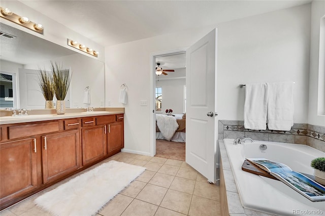 ensuite bathroom featuring double vanity, connected bathroom, tile patterned floors, a sink, and a bath