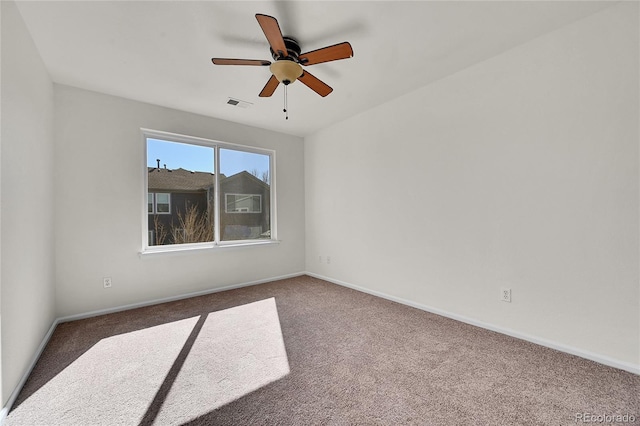 spare room with a ceiling fan, baseboards, visible vents, and carpet flooring