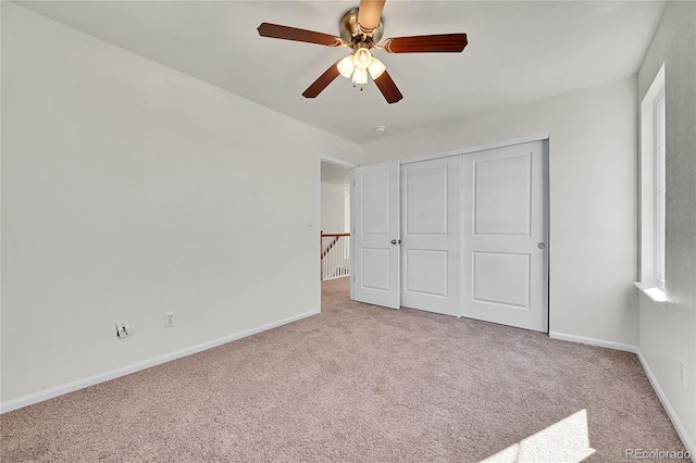 unfurnished bedroom with a ceiling fan, a closet, carpet flooring, and baseboards