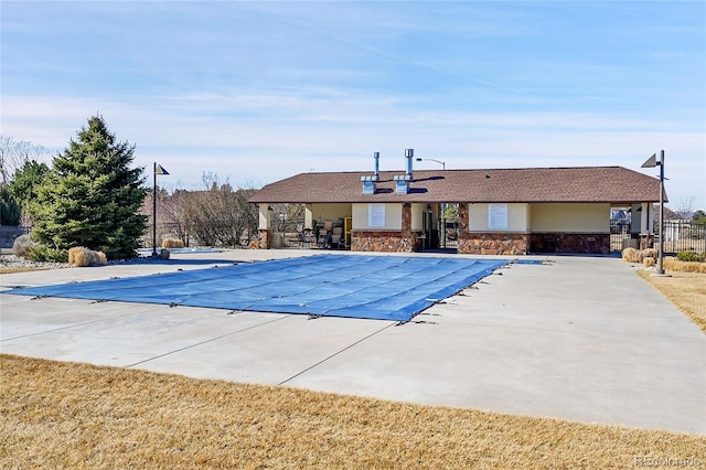 pool with a patio area and fence