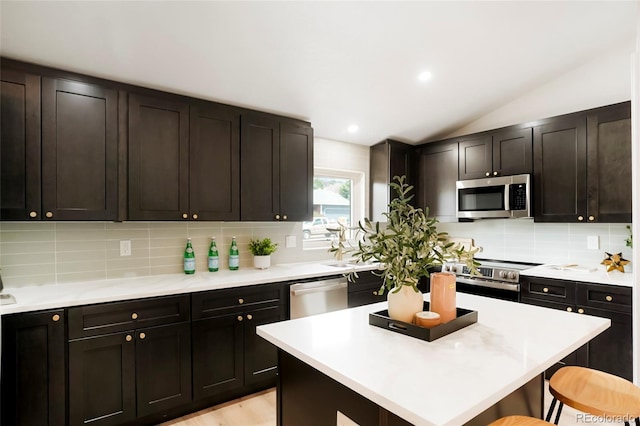 129 Gordon Pl, Castle Rock, CO 80104 - kitchen with light countertops, stainless steel appliances, vaulted ceiling, and a kitchen breakfast bar
