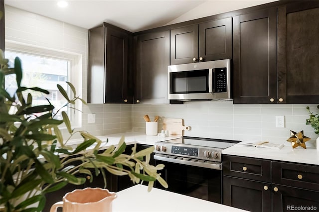 129 Gordon Pl, Castle Rock, CO 80104 - kitchen with light countertops, stainless steel appliances, dark brown cabinets, and tasteful backsplash