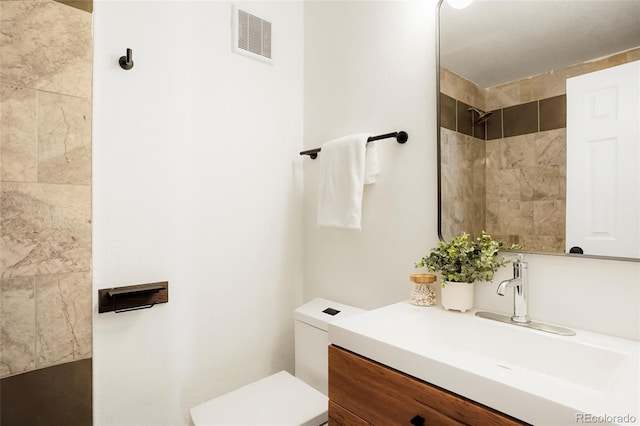 129 Gordon Pl, Castle Rock, CO 80104 - full bathroom featuring visible vents, a tile shower, toilet, and vanity