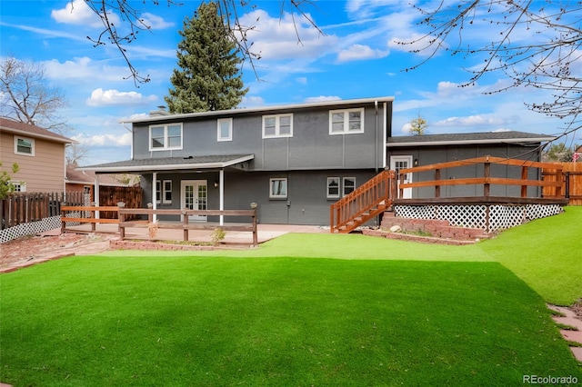 129 Gordon Pl, Castle Rock, CO 80104 - back of property featuring french doors, a wooden deck, a patio area, a fenced backyard, and a yard