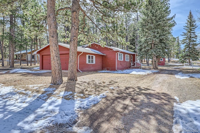 snow covered property with an attached garage