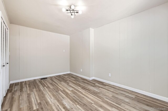 interior space featuring a chandelier, baseboards, visible vents, and wood finished floors