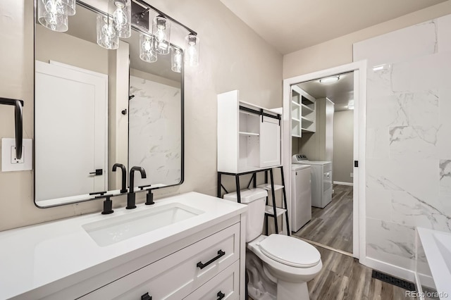 full bathroom featuring vanity, wood finished floors, washing machine and dryer, a washtub, and toilet