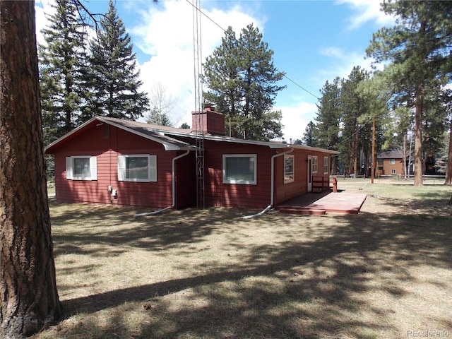 rear view of property with a yard and a chimney