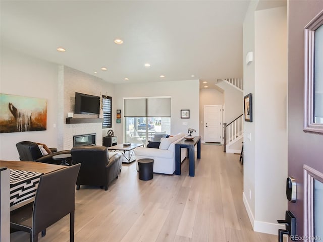 living room featuring a large fireplace and light wood-type flooring