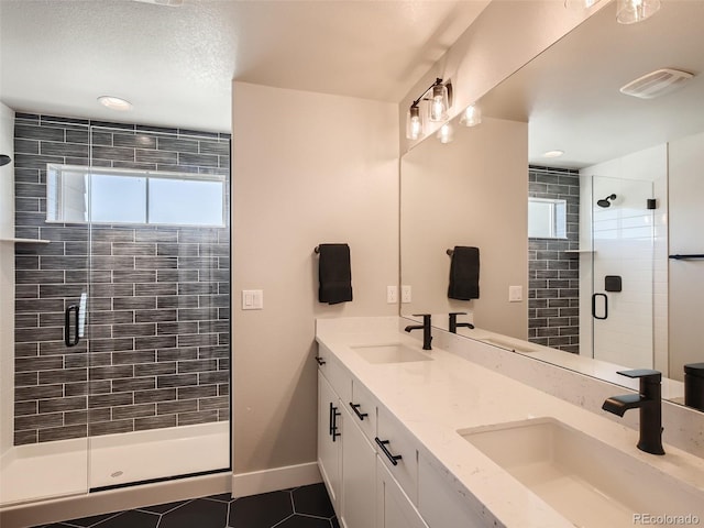 bathroom featuring tile patterned flooring, an enclosed shower, and vanity