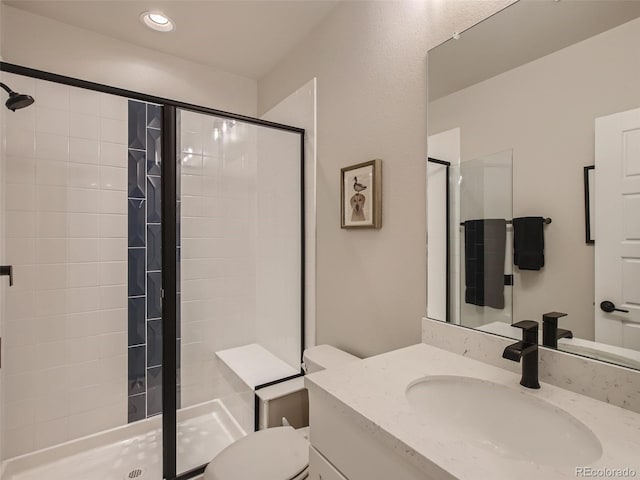 bathroom with vanity, toilet, and a shower with door