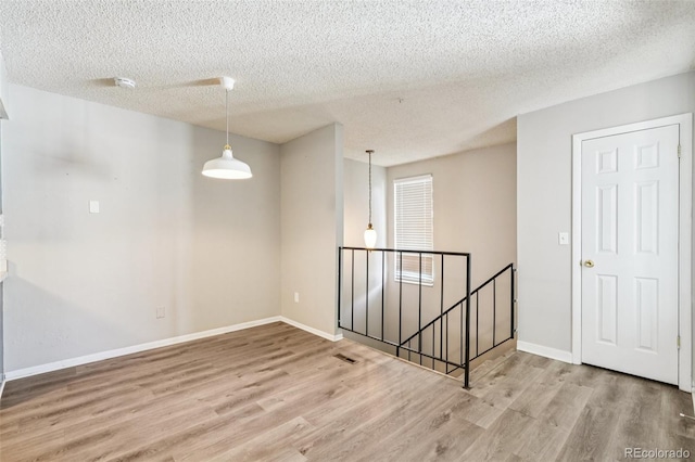 14590 E 13th Ave, Aurora, CO 80011 - empty room with wood finished floors, a textured ceiling, and a smoke detector