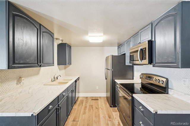 14590 E 13th Ave, Aurora, CO 80011 - kitchen featuring stainless steel appliances, decorative backsplash, light wood-style floors, and light countertops