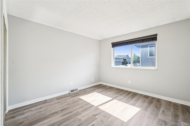 14590 E 13th Ave, Aurora, CO 80011 - unfurnished room with a textured ceiling and wood finished floors