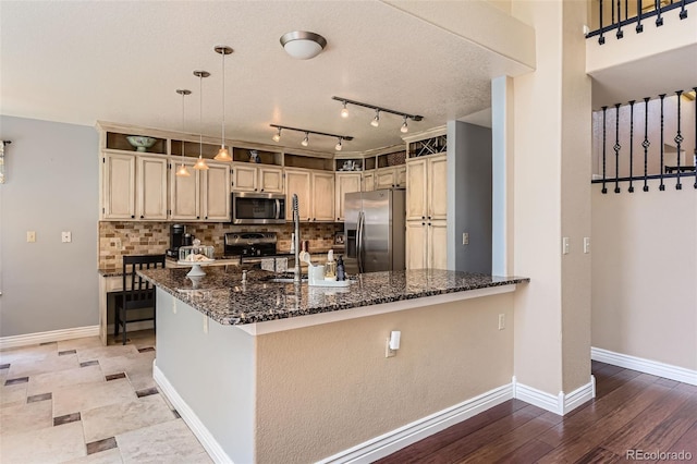 9743 Chanteclair Cir, Highlands Ranch, CO 80126 - kitchen featuring appliances with stainless steel finishes, dark stone counters, decorative backsplash, baseboards, and a peninsula