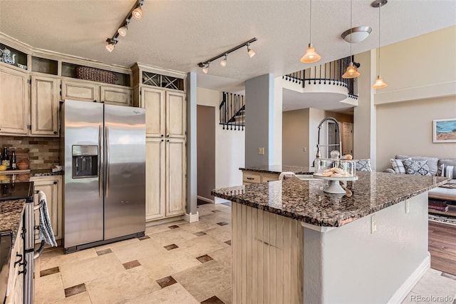 9743 Chanteclair Cir, Highlands Ranch, CO 80126 - kitchen featuring stainless steel appliances, dark stone counters, a sink, decorative backsplash, and a textured ceiling