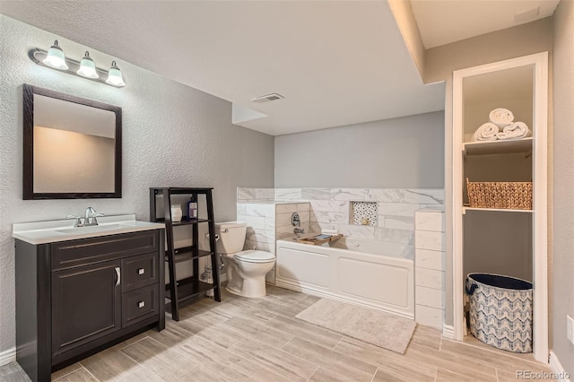 9743 Chanteclair Cir, Highlands Ranch, CO 80126 - full bath featuring toilet, a bath, wood finish floors, vanity, and a textured wall