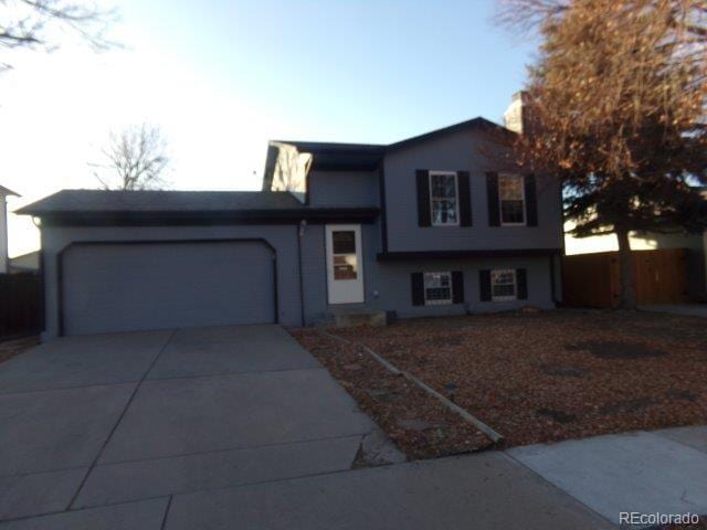 1889 S Flanders Way, Aurora, CO 80017 - tri-level home featuring an attached garage, concrete driveway, and a chimney