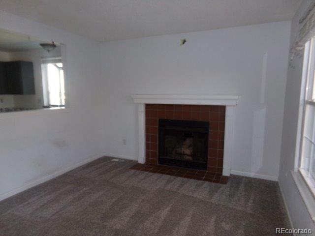 1889 S Flanders Way, Aurora, CO 80017 - unfurnished living room with carpet flooring, a tile fireplace, and plenty of natural light