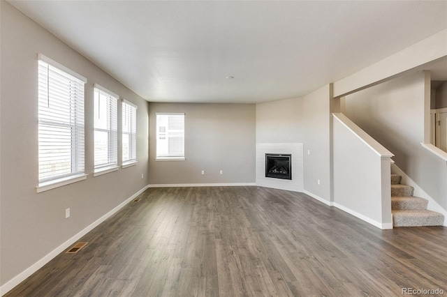 unfurnished living room featuring dark hardwood / wood-style flooring and a fireplace