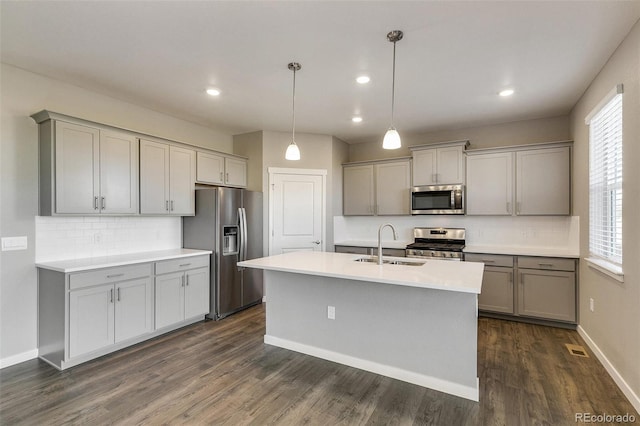 kitchen with pendant lighting, sink, gray cabinetry, and appliances with stainless steel finishes