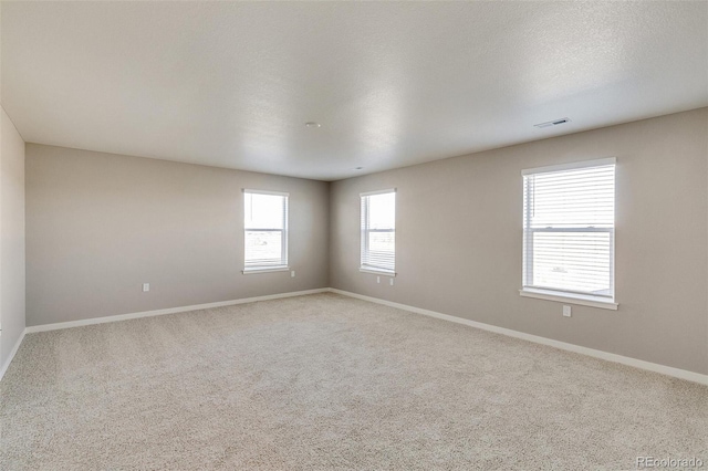 carpeted spare room featuring a textured ceiling