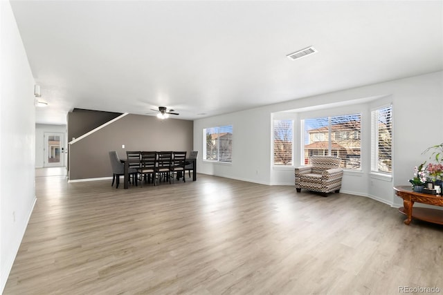 dining room featuring ceiling fan, light wood-type flooring, visible vents, and baseboards