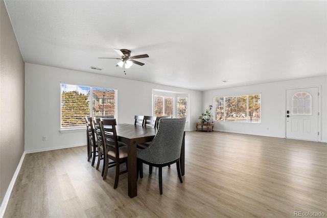 dining area with light wood-type flooring, plenty of natural light, and visible vents