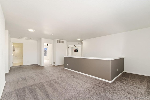 empty room featuring carpet, visible vents, and baseboards