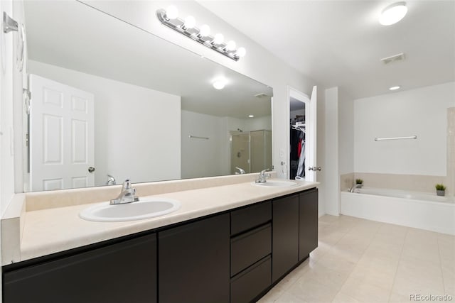 bathroom featuring a spacious closet, a stall shower, a sink, and visible vents