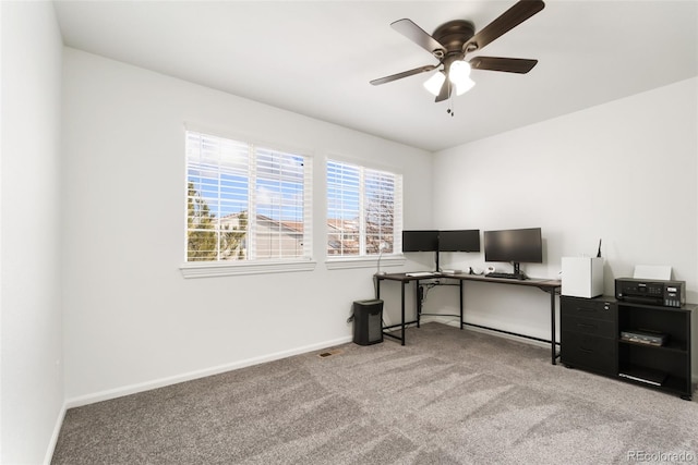 unfurnished office featuring ceiling fan, carpet, and baseboards