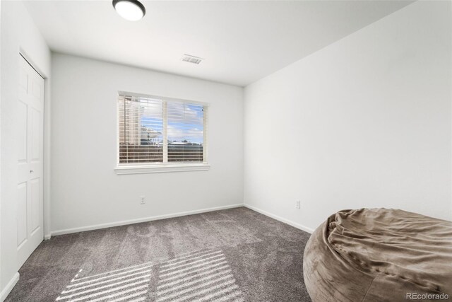 unfurnished bedroom featuring baseboards, a closet, visible vents, and carpet flooring