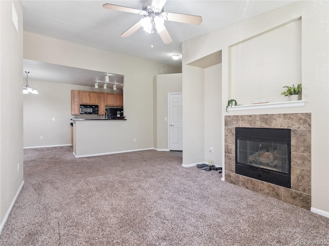 9142 Lodestar Ln Unit 305, Parker, CO 80134 - unfurnished living room featuring carpet floors, a tiled fireplace, a ceiling fan, and a chandelier