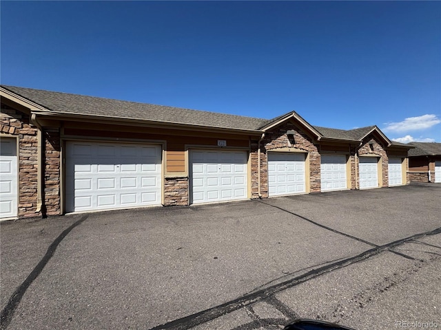 9142 Lodestar Ln Unit 305, Parker, CO 80134 - view of front of home with community garages, stone siding, and roof with shingles