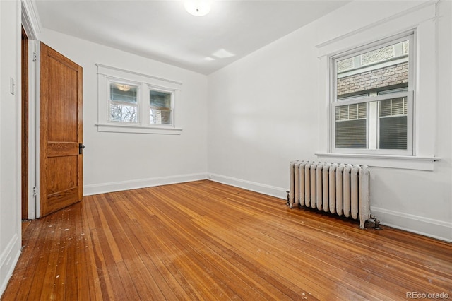 618 Adams St, Denver, CO 80206 - spare room with radiator heating unit, hardwood / wood-style floors, baseboards, and plenty of natural light