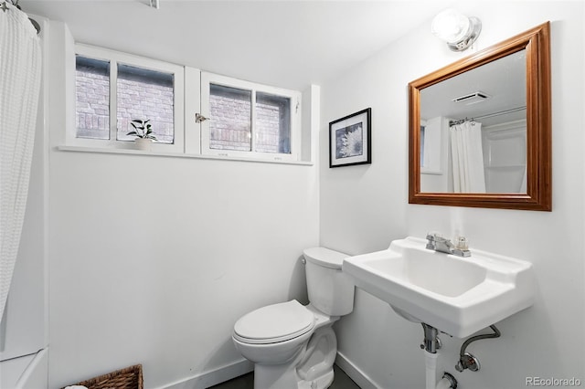 618 Adams St, Denver, CO 80206 - bathroom with baseboards, toilet, curtained shower, and a sink
