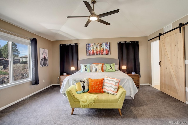 bedroom with lofted ceiling, a barn door, baseboards, and visible vents