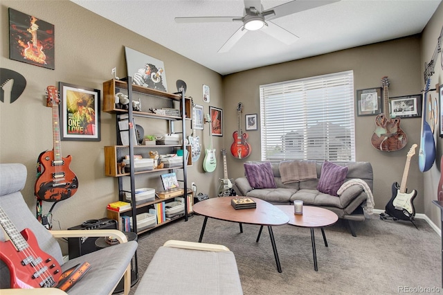 carpeted living room with ceiling fan and baseboards