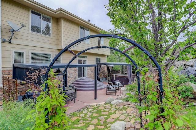 5830 Jasper Pointe Cir, Castle Pines, CO 80108 - rear view of property featuring a hot tub, a patio, and stone siding