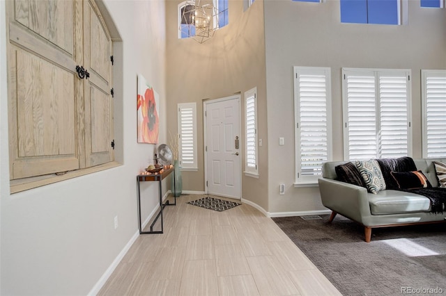 5830 Jasper Pointe Cir, Castle Pines, CO 80108 - entrance foyer featuring a towering ceiling, a chandelier, and baseboards