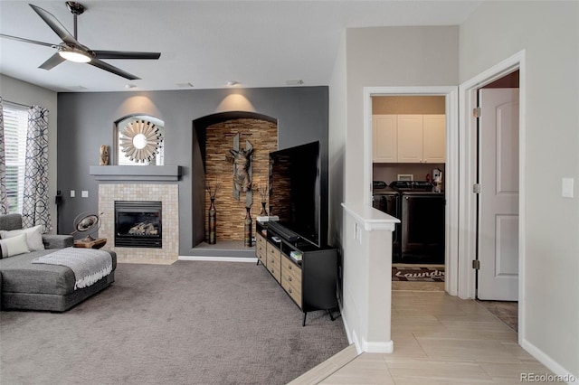 5830 Jasper Pointe Cir, Castle Pines, CO 80108 - living area with independent washer and dryer, a fireplace, ceiling fan, baseboards, and light colored carpet