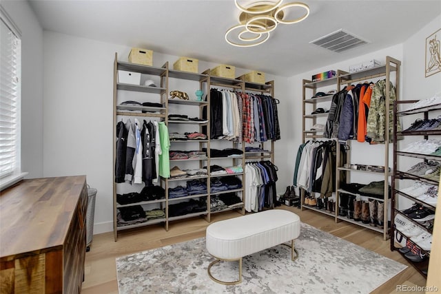 5830 Jasper Pointe Cir, Castle Pines, CO 80108 - walk in closet featuring wood finished floors and a chandelier