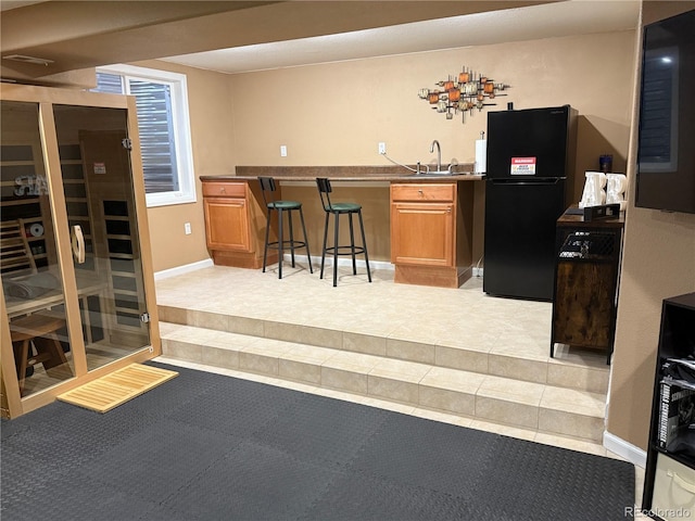 5830 Jasper Pointe Cir, Castle Pines, CO 80108 - indoor wet bar featuring freestanding refrigerator, light tile patterned flooring, and baseboards