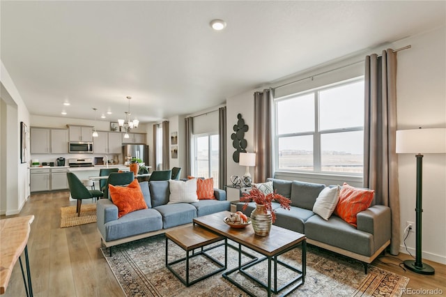 living room featuring an inviting chandelier and light hardwood / wood-style floors